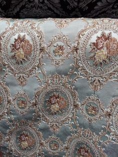 the fabric has been embroidered with gold and blue flowers on it, along with other decorative items