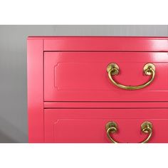 a pink dresser with brass handles and knobs