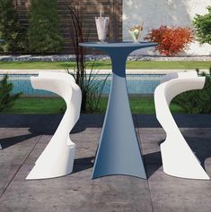 two white vases sitting next to each other on top of a cement slab in front of a pool