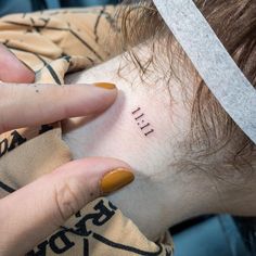 a woman with a small tattoo on her neck and the word hell written in it