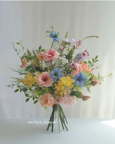 a vase filled with lots of different colored flowers