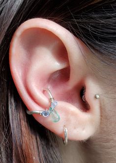 a close up of a person's ear with some piercings on it