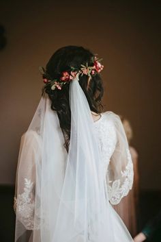 the back of a bride's veil with flowers on her head and hair comb