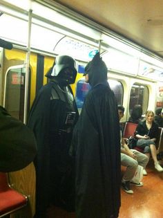 two people dressed as darth vader and batman on a subway train with caption in spanish