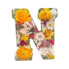 the letter n is decorated with flowers and daisies on it's glass base