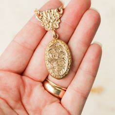 This one-of-a-kind necklace is composed of: Victorian gold filled locket and watch fob connecting link from the late 1800s. The locket features hand engraved scrollwork and floral details. This gold filled necklace measures a standard 18” on a modern 14k gold filled chain. The locket measures 1.25" in length and drops 2" from the chain. Gold-tone Oval Brass Jewelry, Oval Gold-tone Brass Jewelry, Filigree Pendant Jewelry For Keepsake, Gold Pendant Locket Necklace With Vintage Charm, Gold Locket Necklace With Vintage Charm, Brass Locket Necklace For Keepsake, Elegant Filigree Jewelry For Keepsake, Heirloom Brass Necklace For Keepsake, Keepsake Yellow Gold Filigree Jewelry