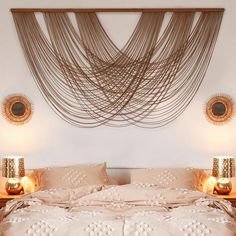 a bed with two lamps on either side of it and a string art hanging over the headboard