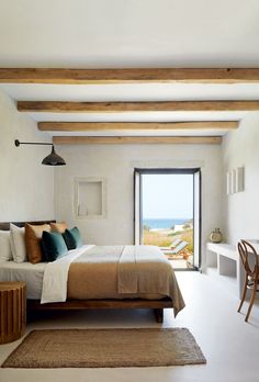 a bedroom with white walls and wooden beams