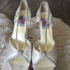 two pairs of white high heeled shoes with bows