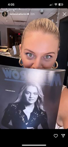 a woman holding up a magazine in front of her face