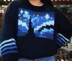 a woman is smiling while wearing a sweater with the image of the starr wars on it