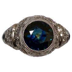 a ring with a blue stone in the center and two rows of diamonds around it