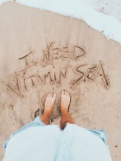 someone is writing in the sand with their feet