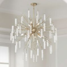 a chandelier hanging from the ceiling in a room with white walls and windows