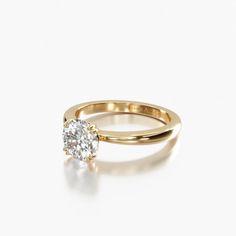 a yellow gold engagement ring set with a round brilliant diamond in the center, on a white background