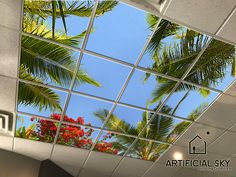 the ceiling in an office building is decorated with palm trees and red bougaries