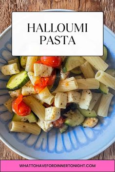 a blue plate topped with pasta and veggies on top of a wooden table