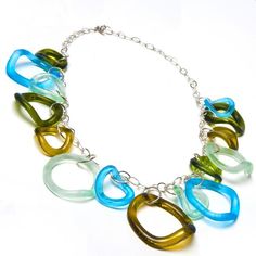 a multicolored necklace is shown on a silver chain and has an oval link