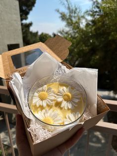 a person holding a box with flowers in it