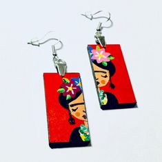 a pair of earrings with an image of a woman wearing a flower in her hair