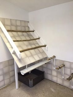 a cat climbing up the side of a stair case in a room with tiled walls