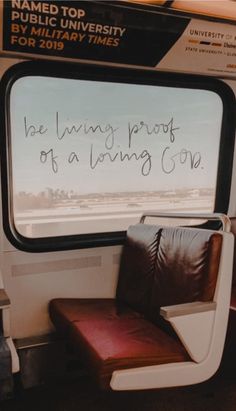 a seat with writing on it in front of a window that reads, be living proof of a loving one