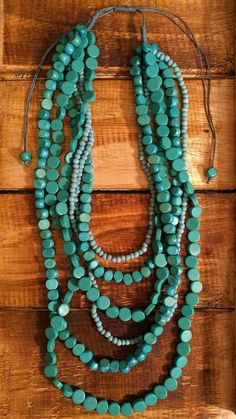 a long necklace with turquoise beads on a wooden surface