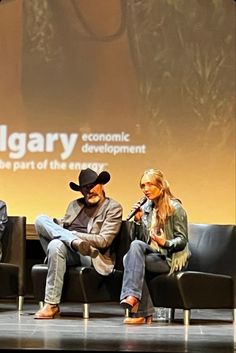 three people sitting on chairs in front of a screen