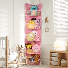 a pink toy storage rack with stuffed animals on it in a child's room