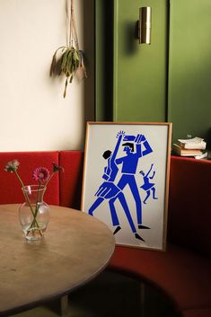 a vase filled with flowers sitting on top of a wooden table next to a painting