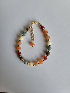 "This Fall bracelet features six opaque Fall colored gemstone beads. The colors are: yellow, orange, green, red, brown and light orange. The gemstones are:  Carnelian, Orange Calcite, Red Aventurine, Yellow Calcite, Burmese Jade and Picture Jasper. The remaining beads and findings are Gold-plated brass. This includes a 1\" extension and lobster claw clasp.  Custom Orders are always welcome! Ask about free sizing." Fall Themed Beaded Bracelet, Fall Bracelets Diy, Beaded Fall Jewelry, Autumn Accessories Jewelry, Fall Inspired Jewelry, Diy Fall Jewelry Ideas, Fall Jewelry Trends 2024, Fall Beaded Bracelet, Colorful Beaded Bracelet