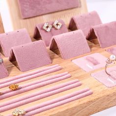 a table topped with lots of different types of rings and earrings on top of pink mats