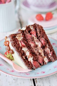 a piece of chocolate cake on a plate with strawberries