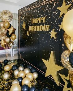 black and gold balloons are in front of a birthday backdrop