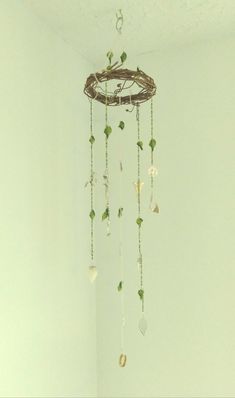 a wind chime hanging from the ceiling in a room with white walls and flooring