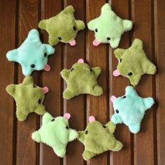 several stuffed animals are arranged in the shape of a star on a wooden table top