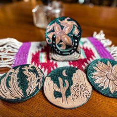 four decorative plates on a table next to a vase