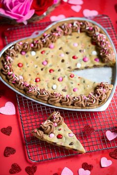 a heart shaped cookie pie on a cooling rack with two pieces missing from the pie