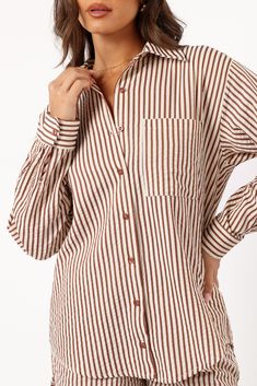 DETAILS    Discover our Kennie Top in Brown Stripe, it's chic relaxed fit is crafted with long sleeves, functional buttons down front, and stylish stripe print â€“ perfect for any season. Unlined for lightweight comfort.    spread collared  long sleeves with button cuff close  functional buttons down front   functional chest pocket  curved hemline  stripe print  relaxed fit  unlined   material - 55% cotton / 45% polyester    SIZING    studio model is 5' 7" and wears a Size S    model stats: bust Casual Vertical Stripes Blouse For Fall, Striped Collared Shirt For Fall, Fall Striped Collared Shirt, Fall Daywear Shirt With Striped Collar, Fall Season Striped Collar Shirt For Daywear, Collared Tops With Vertical Stripes For Fall, Casual Collared Blouse With Vertical Stripes, Vertical Striped Long Sleeve Shirt For Day Out, Vertical Stripes Long Sleeve Shirt For Day Out