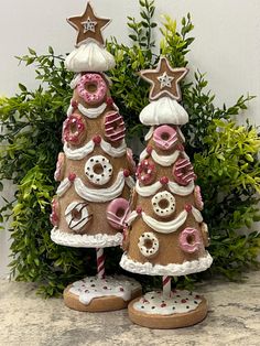 two christmas trees made out of cookies and doughnuts are sitting next to each other