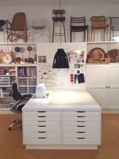 a room filled with lots of white furniture and storage containers on the wall next to it