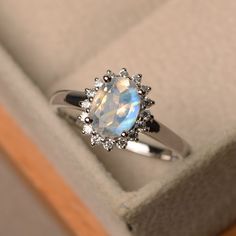 an opal and diamond ring in a box