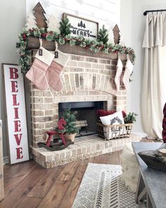 a living room decorated for christmas with stockings on the fireplace