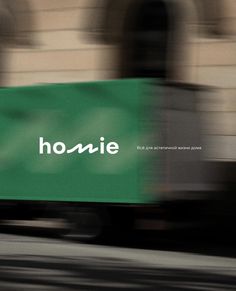 a truck driving past a building with the word homie on it's side