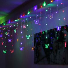 a room filled with lots of colorful lights and butterflies hanging from the ceiling above it