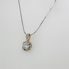 A fine vintage Lady's diamond pendant necklace.  With a round brilliant cut ca. 0.57 ct. diamond center set in a 14k white gold setting.  The center stone is surrounded by 4 smaller RBC diamonds with an approx. 0.12 ct weight.  Together with an associated 14k white gold square snake chain.  Accompanied by a GEMLAB (Gemological Appraisal Laboratory) report.   Simply elegant!   Date: 20th Century  Overall Condition: It is in overall good, as-pictured, used estate condition with some fine & light s White Gold Necklace With Center Round Stone, Diamond Necklace With Center Stone As A Gift, White Gold Necklace With Center Stone, Vintage White Gold Diamond Necklace With Single Cut Diamonds, Silver Diamond Solitaire Necklace, Diamond Necklace With Center Stone In Fine Jewelry Style, Fine Jewelry Diamond Necklace With Center Stone, Fine Jewelry Necklace With Round Center Stone, Fine Jewelry Diamond Necklace With Center Stone As Gift