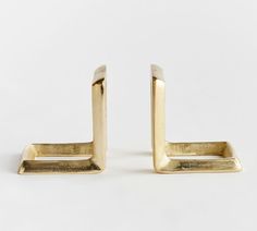 pair of gold - plated metal bookends with rectangular ends on white background