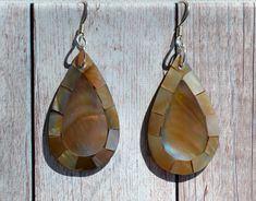 These beautiful earrings feature cross- cut sections of Brown Mother of Pearl (Flat Lip Oyster) in a Teardrop shape. The iridescence of these Mother of Pearl is really amazing. Depending on the angle of the light source they will radiate colors from Browns to Pinks. The shells are then polished to a high gloss to reveal the beauty of their natural pattern. DETAIL - Shell types :Brown Mother of Pearl Shell - Material: Sterling Silver Ear Wire and Jump Ring - Backside of earrings bonded with black Teardrop Fish Hook Earrings Gift, Handmade Teardrop Earrings For Beach, Brown Teardrop Earrings For The Beach, Brown Teardrop Earrings For Beach, Shell Types, Jewelry Island, Island Jewelry, Hawaiian Jewelry, Beach Earrings