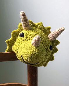 a crocheted stuffed animal sitting on top of a wooden chair