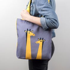 This handmade giraffe tote bag is full of fun and big in character and very practical too! A great gift for a giraffe lover! The animal canvas tote bag is perfect for a kids book bag, a school bag, shopping bag or a beach bag! An ideal gift for her. The front of the bag has two jungle giraffes illustrated with in yellows, blacks and whites on a grey background in a Scandinavian style. The reverse and handles are in a matching yellow canvas strong material. It is folded neatly and packaged with a Yellow Canvas Bag As Gift, Playful Cotton Bag For Gift, Animal Design Tote Bag As Gift, Animal Design Tote Bag For Gift, Playful Tote Canvas Gift Bag, Yellow Canvas Tote Bag For Gifts, Yellow Tote Canvas Bag Gift, Yellow Tote Canvas Bag For Gift, Metallic Wrapping Paper